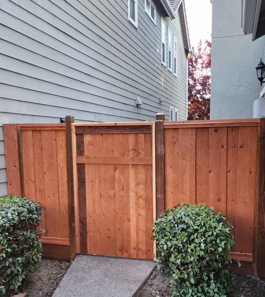 New redwood gate in light brown stain with dark brown accents.
